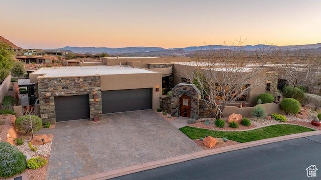 3052 N Snow Canyon Pkwy Unit 67, St George, UT 84770 - pueblo revival-style home featuring decorative driveway, stone siding, a mountain view, a garage, and stucco siding