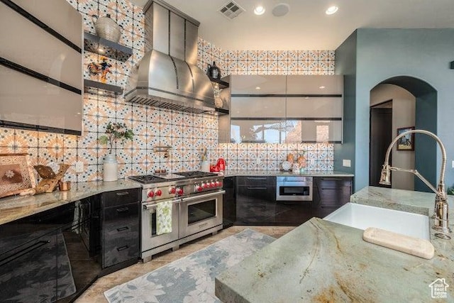 3052 N Snow Canyon Pkwy Unit 67, St George, UT 84770 - kitchen with wall chimney range hood, tasteful backsplash, arched walkways, stainless steel appliances, and visible vents