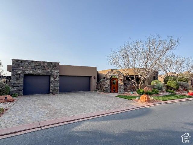 3052 N Snow Canyon Pkwy Unit 67, St George, UT 84770 - view of front facade featuring stucco siding, an attached garage, decorative driveway, and stone siding