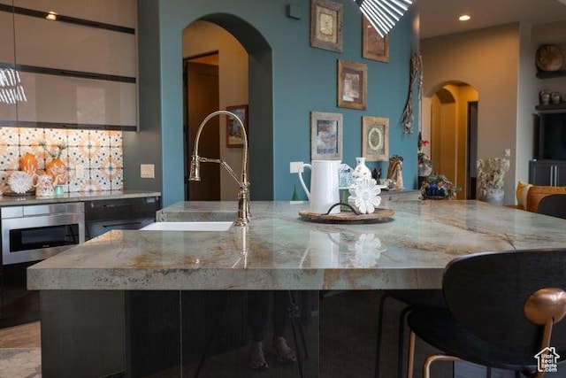 3052 N Snow Canyon Pkwy Unit 67, St George, UT 84770 - kitchen with a sink, oven, a breakfast bar, arched walkways, and recessed lighting