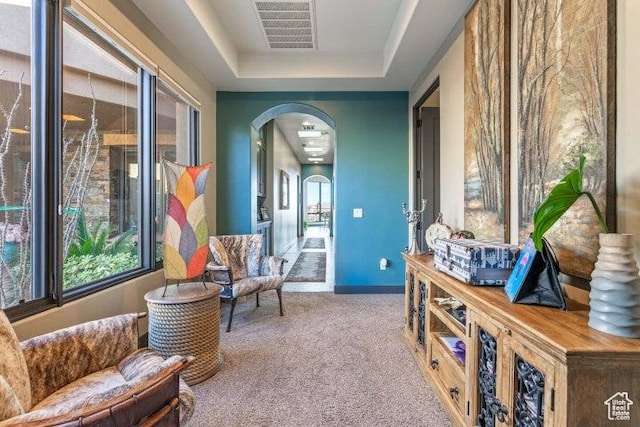 3052 N Snow Canyon Pkwy Unit 67, St George, UT 84770 - living area featuring carpet flooring, arched walkways, baseboards, visible vents, and a raised ceiling