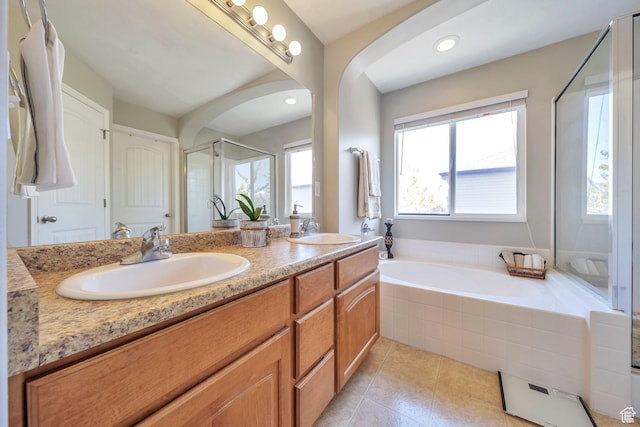 bathroom featuring a shower stall, a garden tub, tile patterned flooring, and a sink