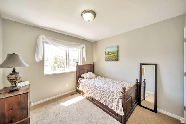 bedroom with baseboards and light colored carpet