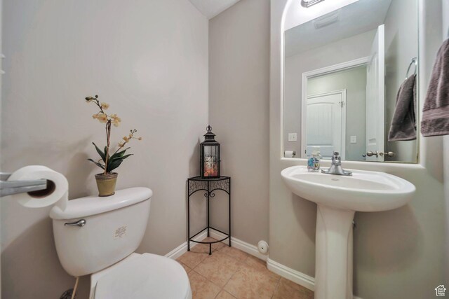 bathroom with tile patterned floors, baseboards, and toilet