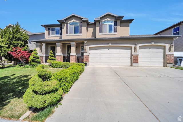 craftsman house featuring driveway, brick siding, an attached garage, a front yard, and stucco siding