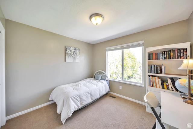 bedroom with carpet floors, visible vents, and baseboards