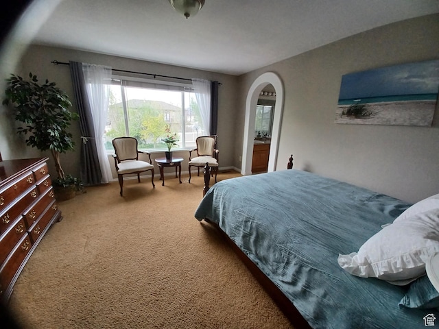 carpeted bedroom with arched walkways
