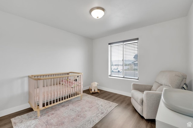 614 S Woodruff Way, Grantsville, UT 84029 - bedroom with wood finished floors, a crib, and baseboards