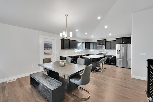 614 S Woodruff Way, Grantsville, UT 84029 - dining room featuring recessed lighting, lofted ceiling, baseboards, a chandelier, and light wood-style flooring