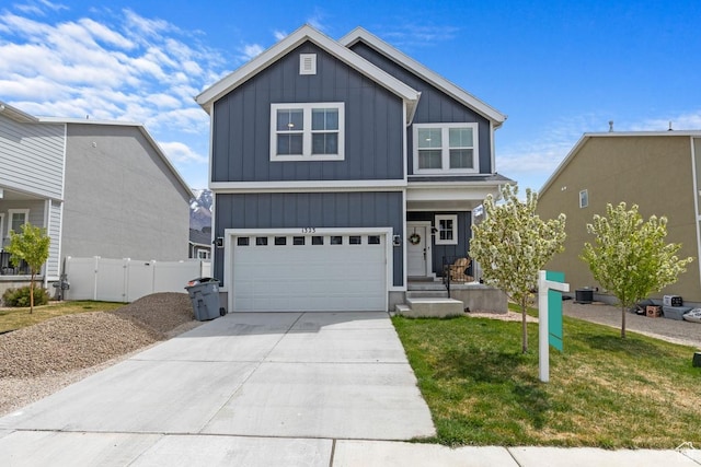 modern farmhouse featuring a garage, concrete driveway, board and batten siding, fence, and a front yard