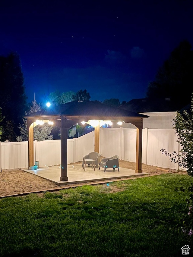 patio at twilight with a fenced backyard and a yard
