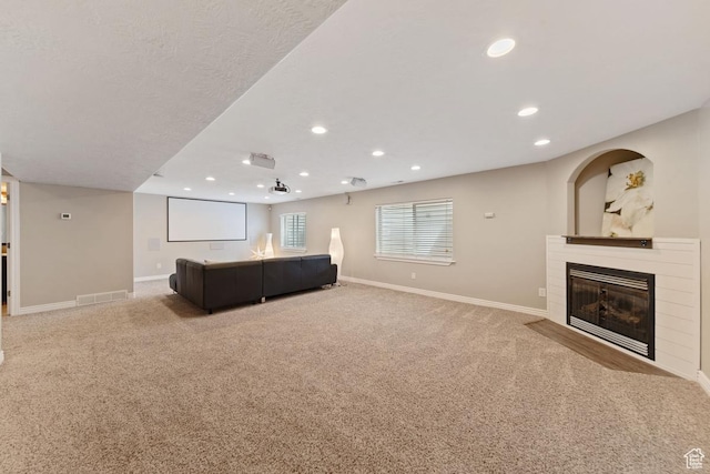 carpeted living room with recessed lighting, a fireplace with flush hearth, visible vents, and baseboards
