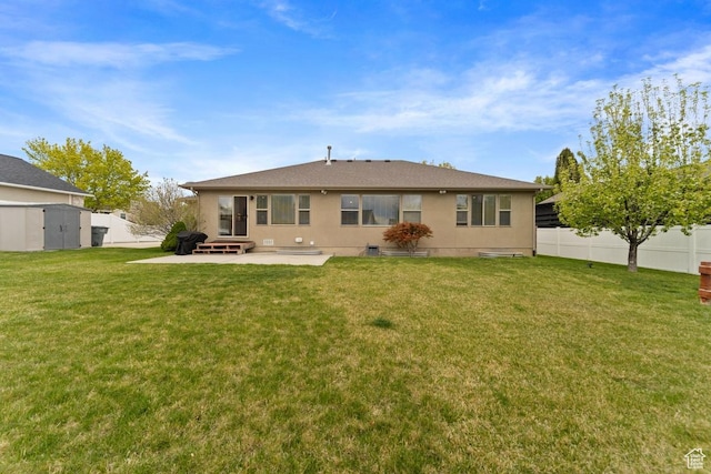 rear view of house with a fenced backyard, a shed, a yard, and a patio