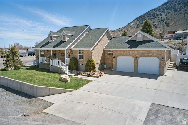 150 S Haulage Rd, Eureka, UT 84628 - view of front of home with a shingled roof, a mountain view, an attached garage, brick siding, and a front lawn