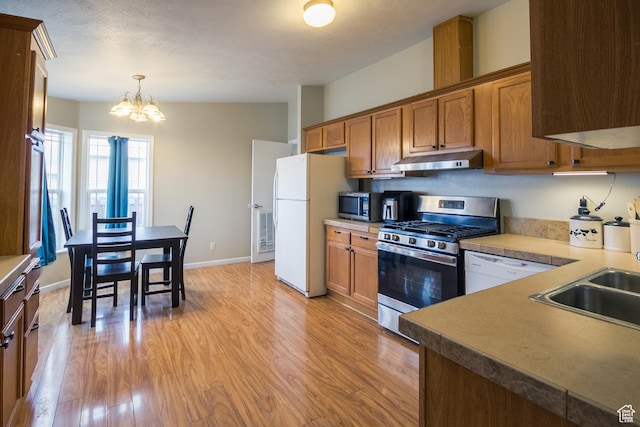 303 W 2000 S, Vernal, UT 84078 - kitchen with an inviting chandelier, a sink, stainless steel appliances, under cabinet range hood, and light wood-type flooring