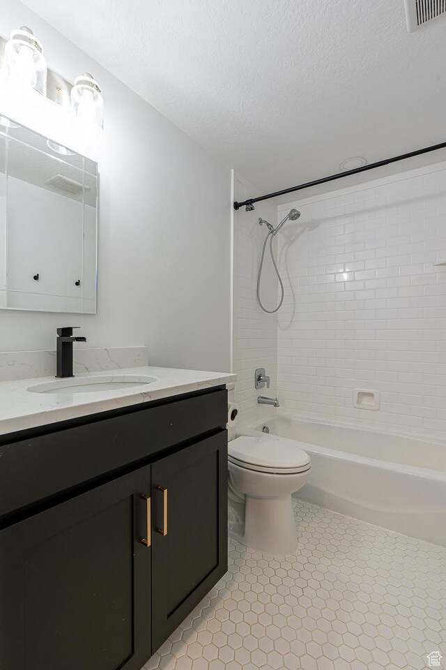 326 E 200 S, Logan, UT 84321 - bathroom with vanity, toilet, a textured ceiling, tile patterned flooring, and shower / washtub combination