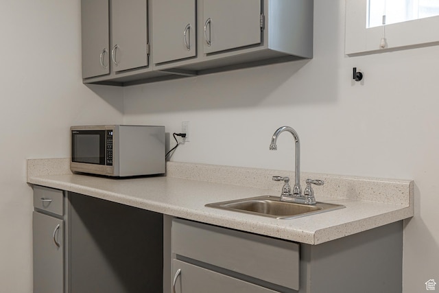 326 E 200 S, Logan, UT 84321 - kitchen with stainless steel microwave, gray cabinetry, light countertops, and a sink