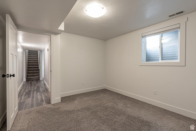 326 E 200 S, Logan, UT 84321 - below grade area with stairway, dark colored carpet, baseboards, visible vents, and a textured ceiling