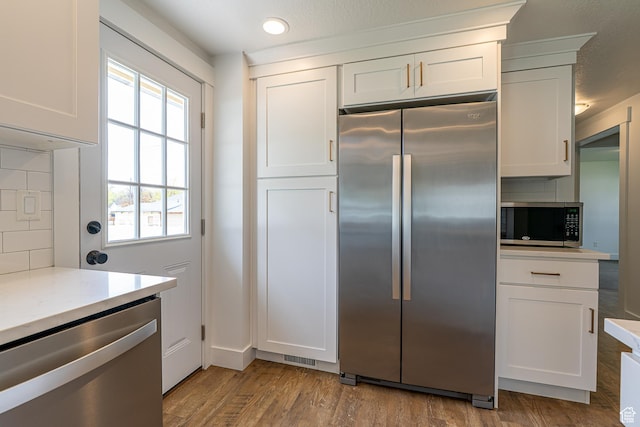 326 E 200 S, Logan, UT 84321 - kitchen with stainless steel appliances, decorative backsplash, white cabinetry, light countertops, and wood finished floors