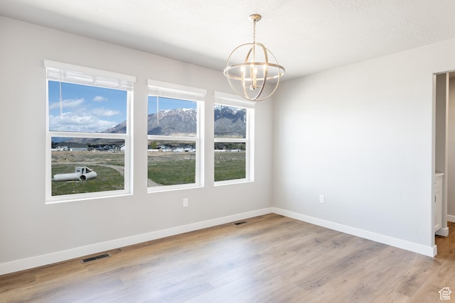 2552 W 2950 N Unit 119, Farr West, UT 84404 - unfurnished dining area featuring baseboards, a notable chandelier, light wood-style floors, and visible vents