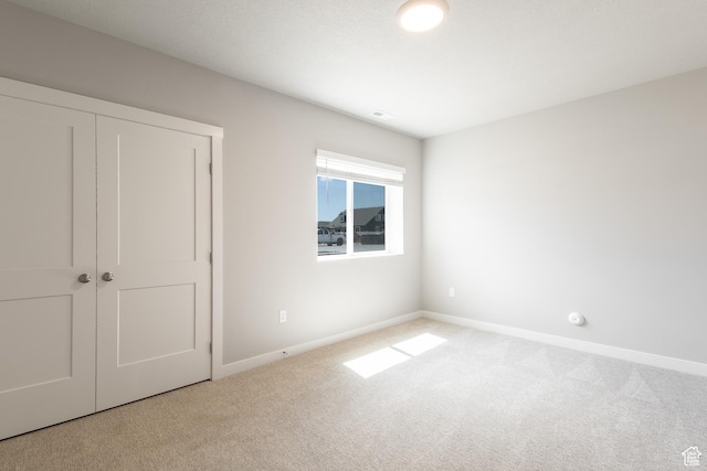 2552 W 2950 N Unit 119, Farr West, UT 84404 - unfurnished bedroom featuring a closet, carpet floors, and baseboards