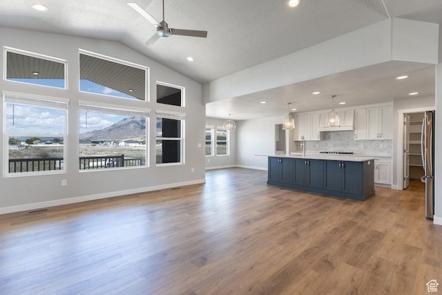 2552 W 2950 N Unit 119, Farr West, UT 84404 - kitchen featuring white cabinetry, light countertops, premium range hood, freestanding refrigerator, and open floor plan