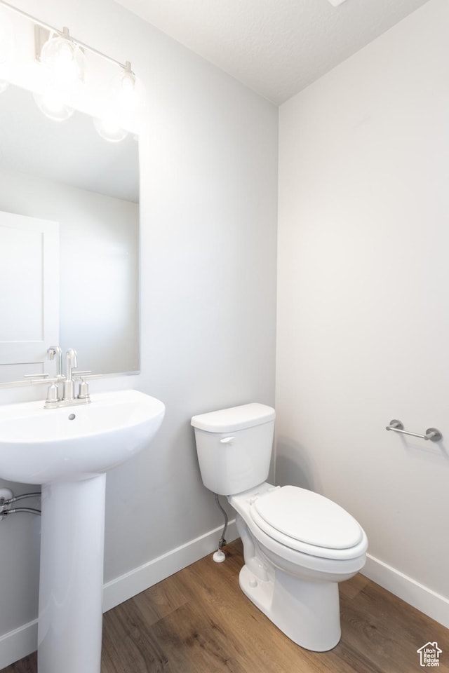 2552 W 2950 N Unit 119, Farr West, UT 84404 - bathroom with wood finished floors, toilet, baseboards, and a sink