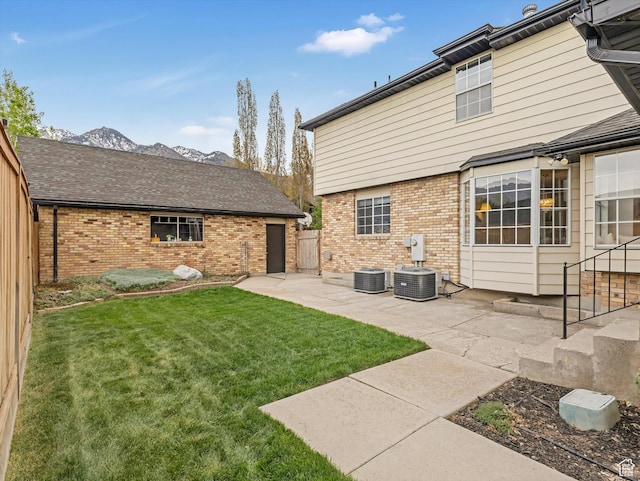 3131 E Alta Hills Dr S, Cottonwood Heights, UT 84093 - rear view of house with brick siding, a patio area, a lawn, and central air condition unit