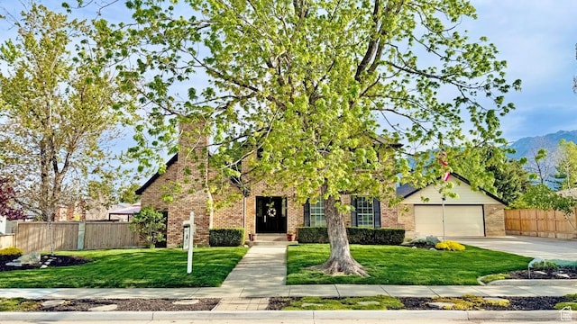3131 E Alta Hills Dr S, Cottonwood Heights, UT 84093 - view of front facade with fence, concrete driveway, brick siding, and a front yard
