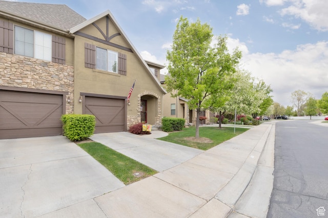 7170 S 420 E, Midvale, UT 84047 - view of front facade with stucco siding, driveway, an attached garage, and stone siding