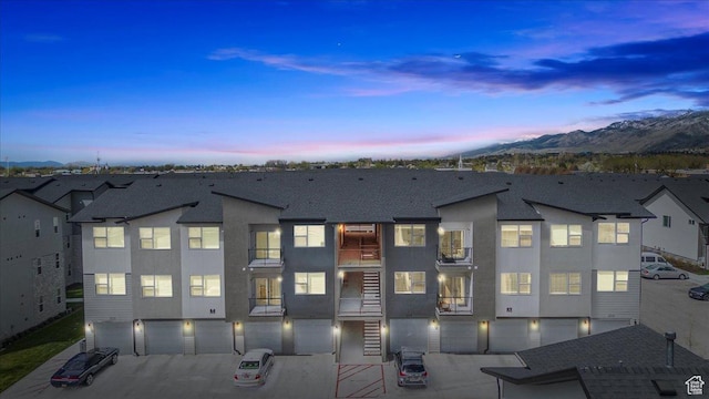463 W 60 S Unit M204, Providence, UT 84332 - view of front of property with stucco siding, a garage, driveway, roof with shingles, and a mountain view