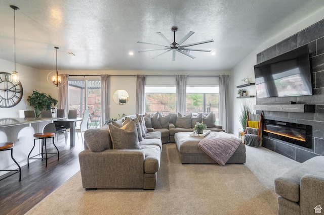 658 N Sage Crest Dr, Washington, UT 84780 - living area featuring a fireplace, visible vents, a textured ceiling, wood finished floors, and ceiling fan with notable chandelier