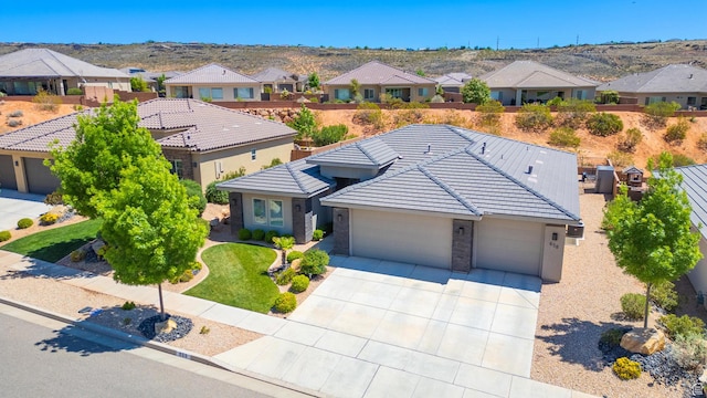 view of front of property with driveway, a tiled roof, an attached garage, and a residential view