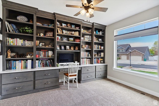 office space featuring carpet, visible vents, a ceiling fan, and baseboards