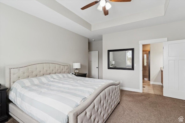 bedroom featuring baseboards, a raised ceiling, a ceiling fan, and carpet