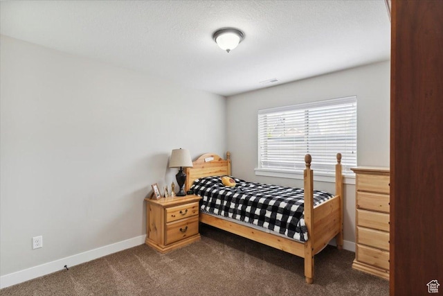 bedroom with dark carpet, visible vents, and baseboards