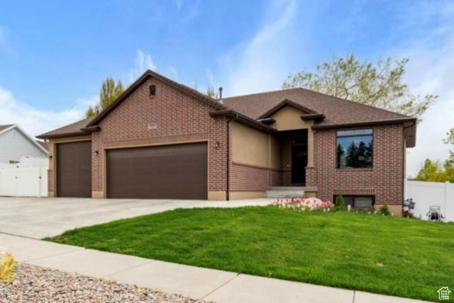 single story home featuring concrete driveway, a front yard, an attached garage, fence, and brick siding