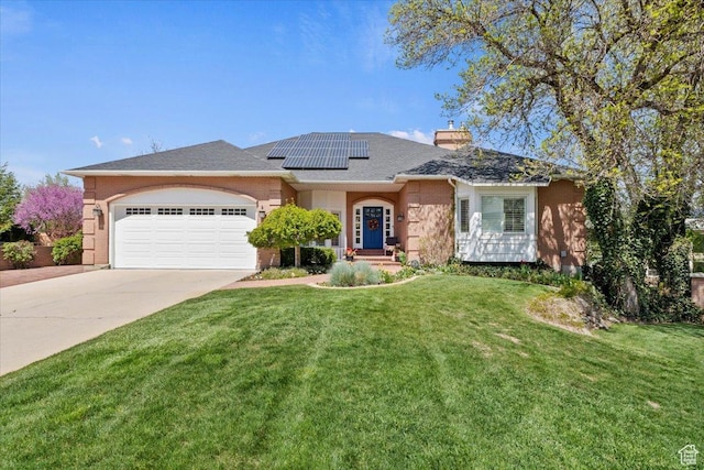 single story home with a front yard, driveway, a chimney, solar panels, and an attached garage