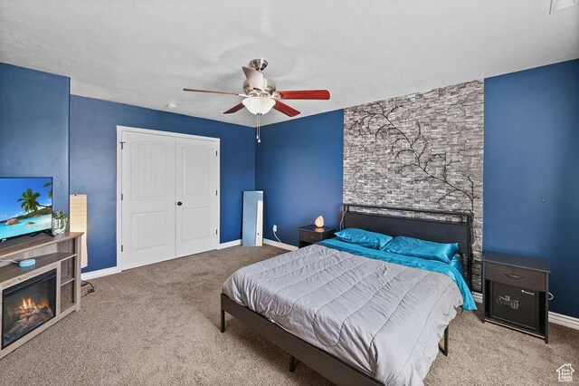 1410 S 4100 W, Syracuse, UT 84075 - carpeted bedroom featuring a closet, ceiling fan, baseboards, and a glass covered fireplace