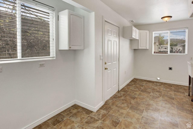 6497 W King Valley Rd, West Valley City, UT 84128 - washroom featuring electric dryer hookup, baseboards, cabinet space, and stone finish floor