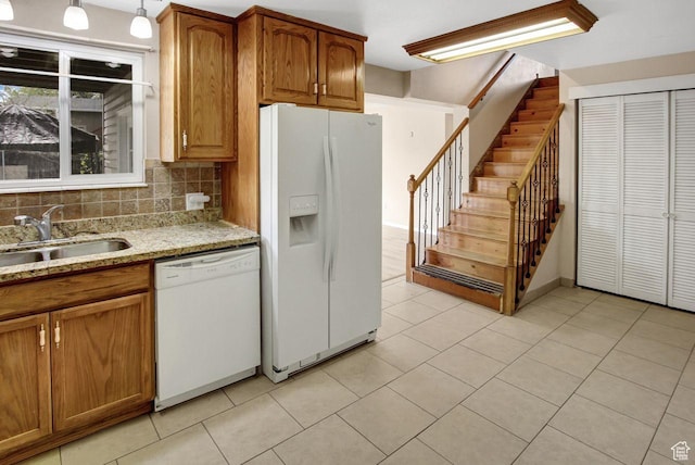 6497 W King Valley Rd, West Valley City, UT 84128 - kitchen with light stone countertops, a sink, light tile patterned flooring, brown cabinetry, and white appliances