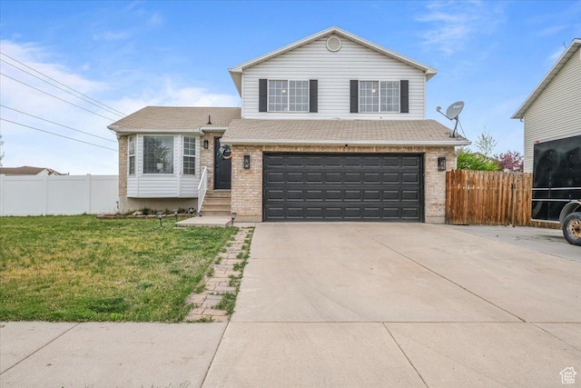 tri-level home featuring a front yard, brick siding, a garage, and fence