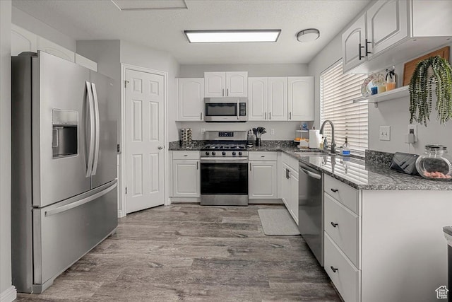 4799 S 3950 W, Roy, UT 84067 - kitchen with dark stone countertops, wood finished floors, appliances with stainless steel finishes, white cabinets, and a sink