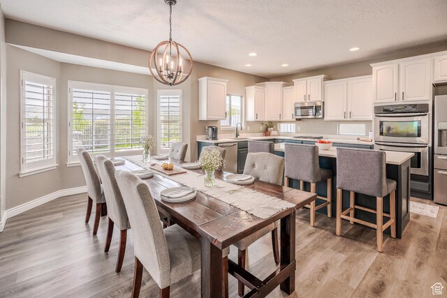 9061 N Clubhouse Ln, Eagle Mountain, UT 84005 - dining space with baseboards, recessed lighting, an inviting chandelier, and light wood-style flooring