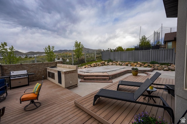 9061 N Clubhouse Ln, Eagle Mountain, UT 84005 - deck featuring an outdoor kitchen, a mountain view, and a fenced backyard