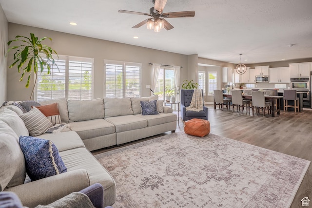 9061 N Clubhouse Ln, Eagle Mountain, UT 84005 - living room with recessed lighting, light wood-style flooring, and ceiling fan with notable chandelier