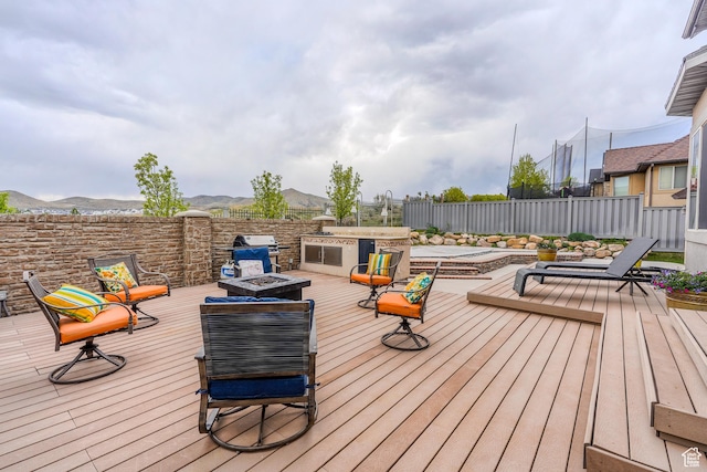 9061 N Clubhouse Ln, Eagle Mountain, UT 84005 - deck featuring grilling area, a mountain view, a fenced backyard, and an outdoor fire pit