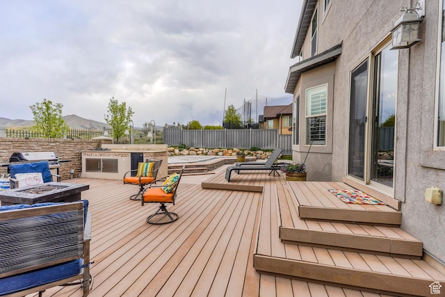 9061 N Clubhouse Ln, Eagle Mountain, UT 84005 - wooden terrace with area for grilling, an outdoor fire pit, a mountain view, a fenced backyard, and a grill