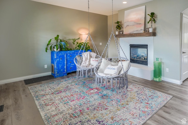 9061 N Clubhouse Ln, Eagle Mountain, UT 84005 - living area with a glass covered fireplace, wood finished floors, and baseboards