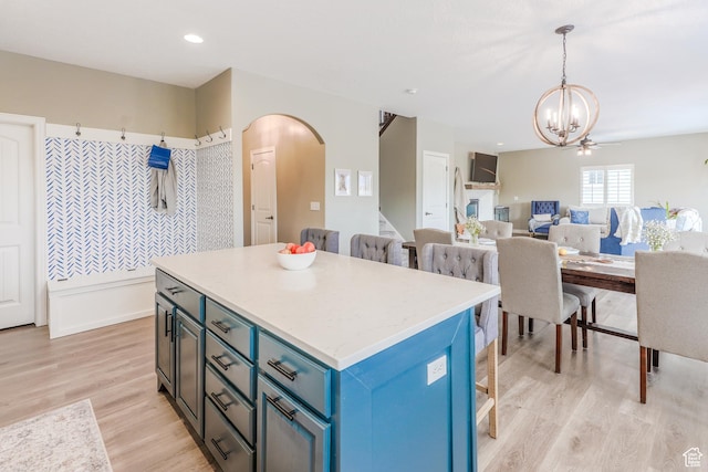9061 N Clubhouse Ln, Eagle Mountain, UT 84005 - kitchen with an inviting chandelier, a kitchen bar, a kitchen island, arched walkways, and blue cabinets